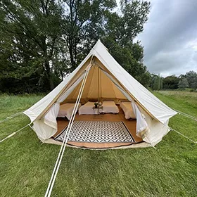 A white bell tent in a field